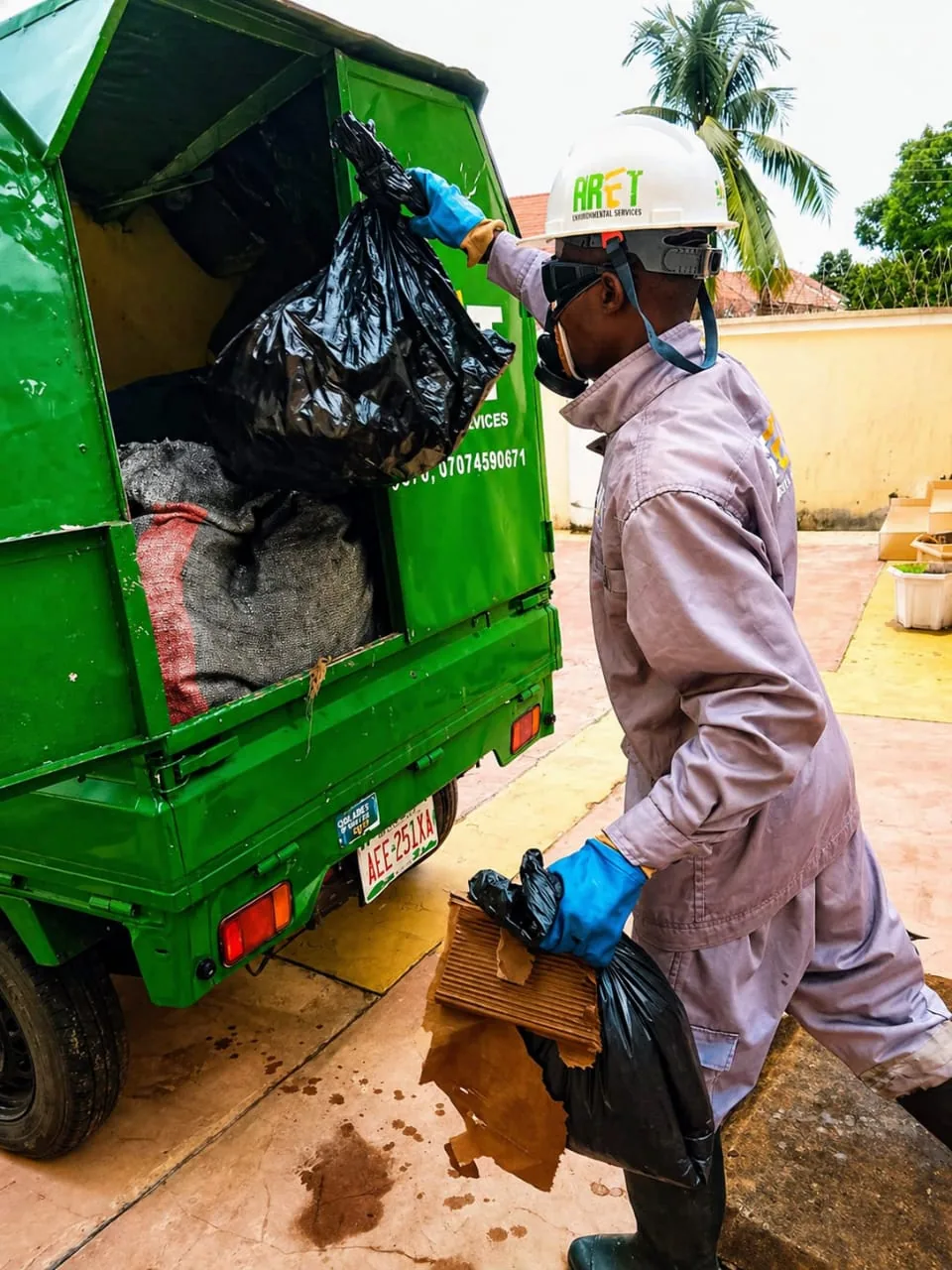 ARET field worker loading bagged waste into a service vehicle